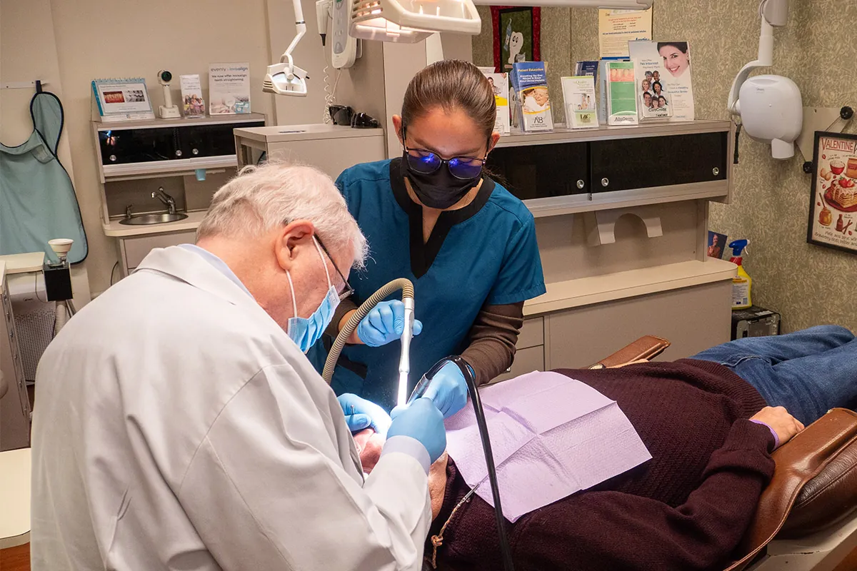 Dr. Hughes and dental assistant in Sterling, VA installing a dental implant for a patient